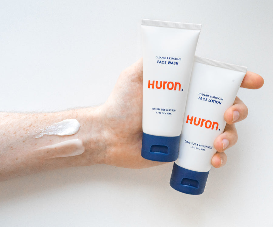 Two Huron skincare products: Face Wash and Face Lotion, with a swatch of lotion on the arm.