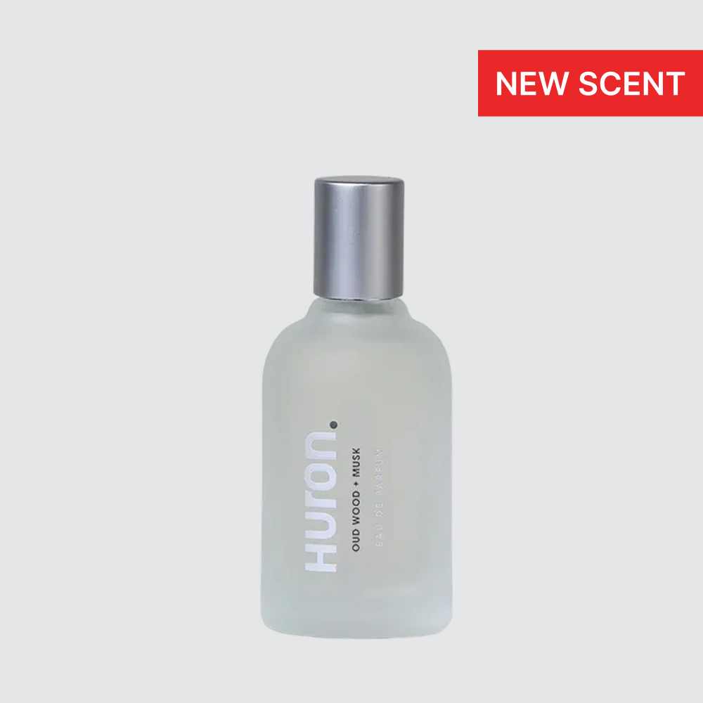 Frosted glass Huron. bottle with silver cap; label reads OUD WOOD + MUSK; red badge NEW SCENT #scent_oud wood + musk