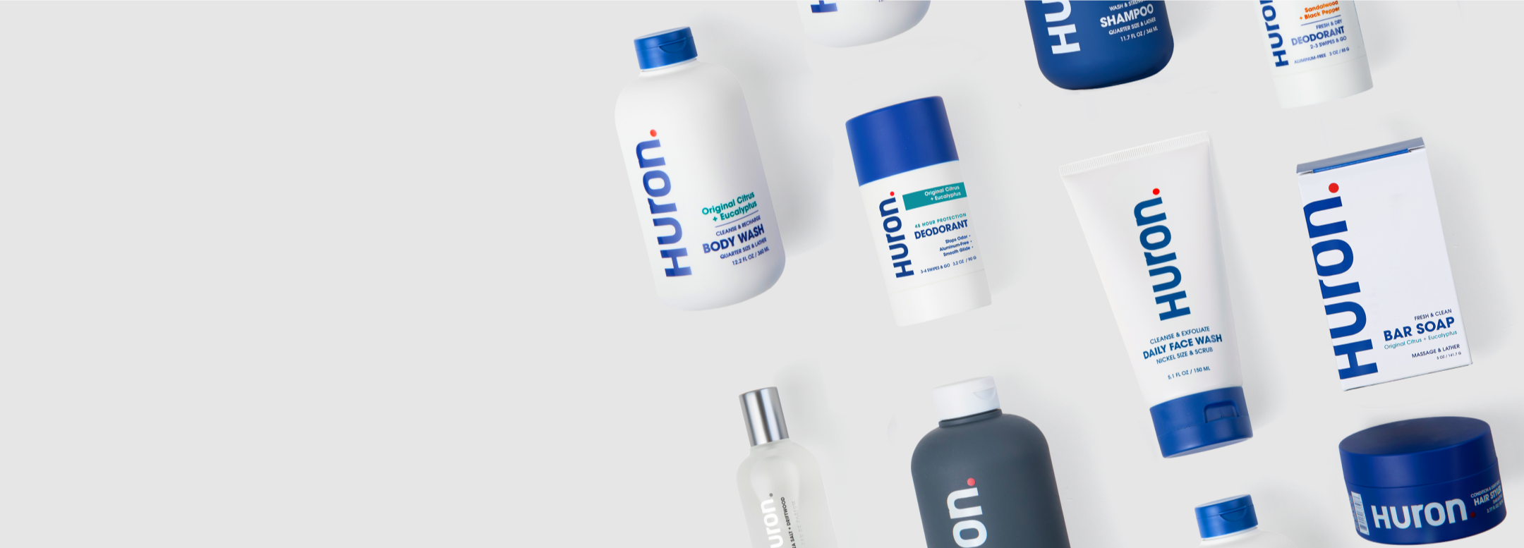 Huron products arranged on pale background: Huron, BODY WASH, DEODORANT, DAILY FACE WASH, BAR SOAP, SHAMPOO, HAIR