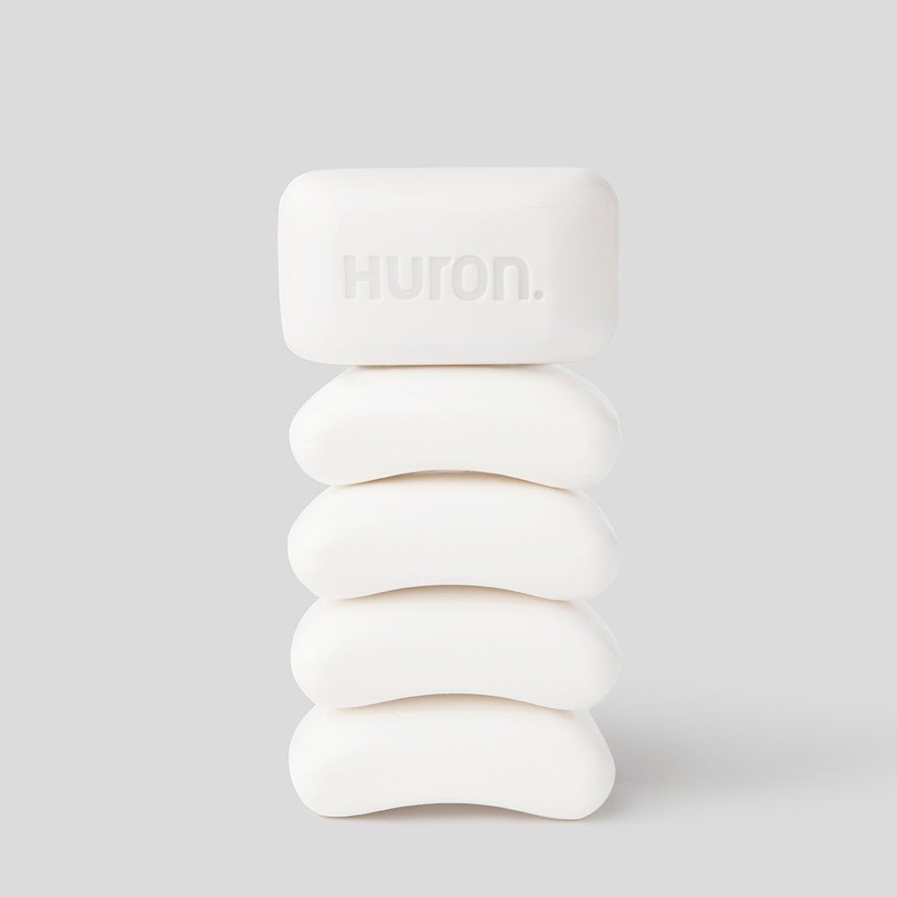 Five stacked white bars of soap with the word 'Huron' embossed on the top bar