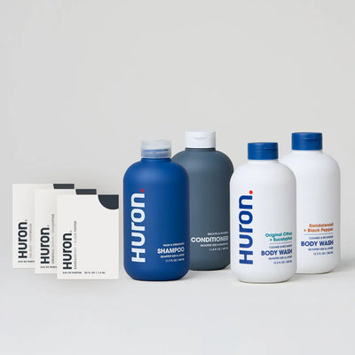 HURON shampoo, conditioner, and body washes in various bottles with two sample packets