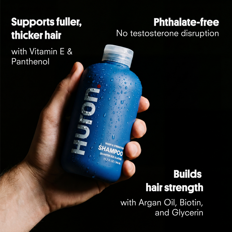 Hand holding blue HUTTON shampoo bottle; visible copy: fuller, thicker hair; Vitamin E, Argan Oil, Biotin.
