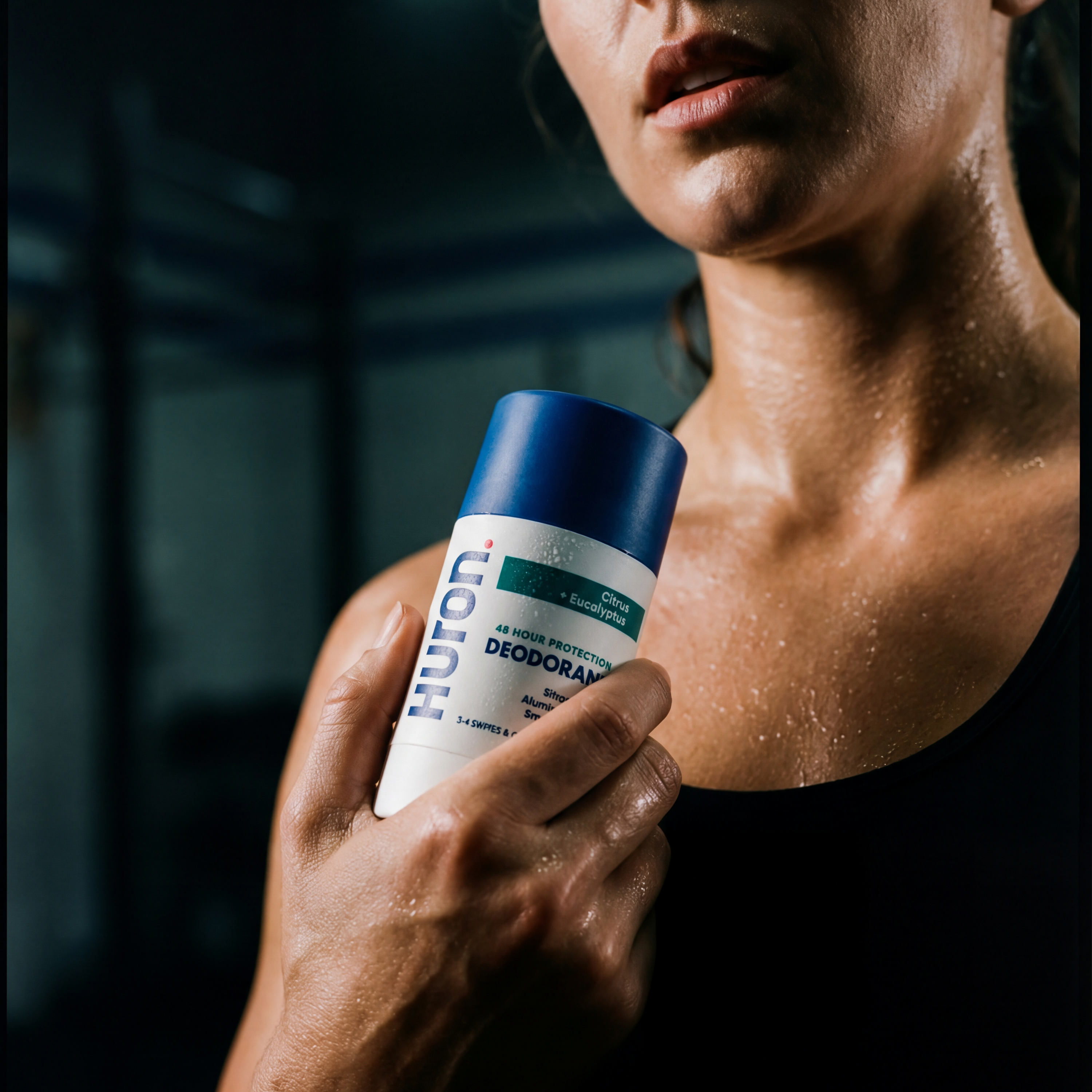 Sweaty woman holding a stick deodorant labeled HURON, '48 HOUR PROTECTION', 'DEODORANT', 'Citrus + Eucalyptus', '3-4 SWIPES & GO'.