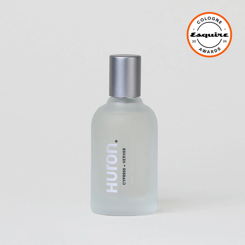 Frosted glass bottle of Huron cologne with text 'CYPRESS + VETIVER EAU DE PARFUM' and silver cap, with Esquire Cologne Awards 2024 badge #scent_cypress + vetiver