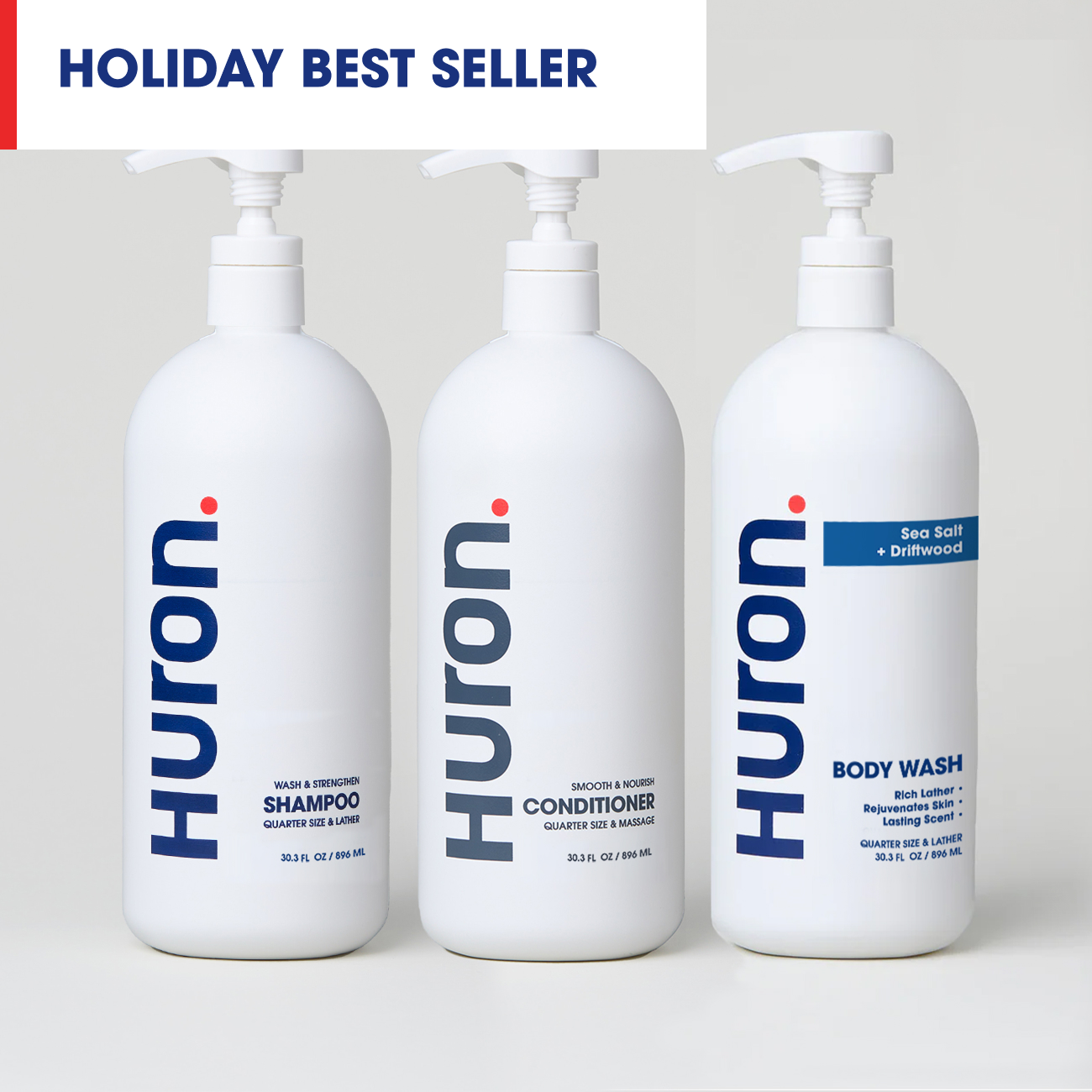 Three Huron pump bottles labeled SHAMPOO, CONDITIONER, BODY WASH; banner 'HOLIDAY BEST SELLER'; red badge 'SAVE $37'; tag 'Sea Salt + Driftwood'.
