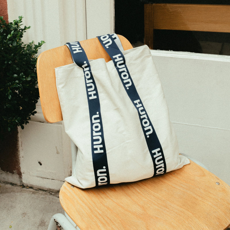 Huron Tote Bag with blue straps on a chair