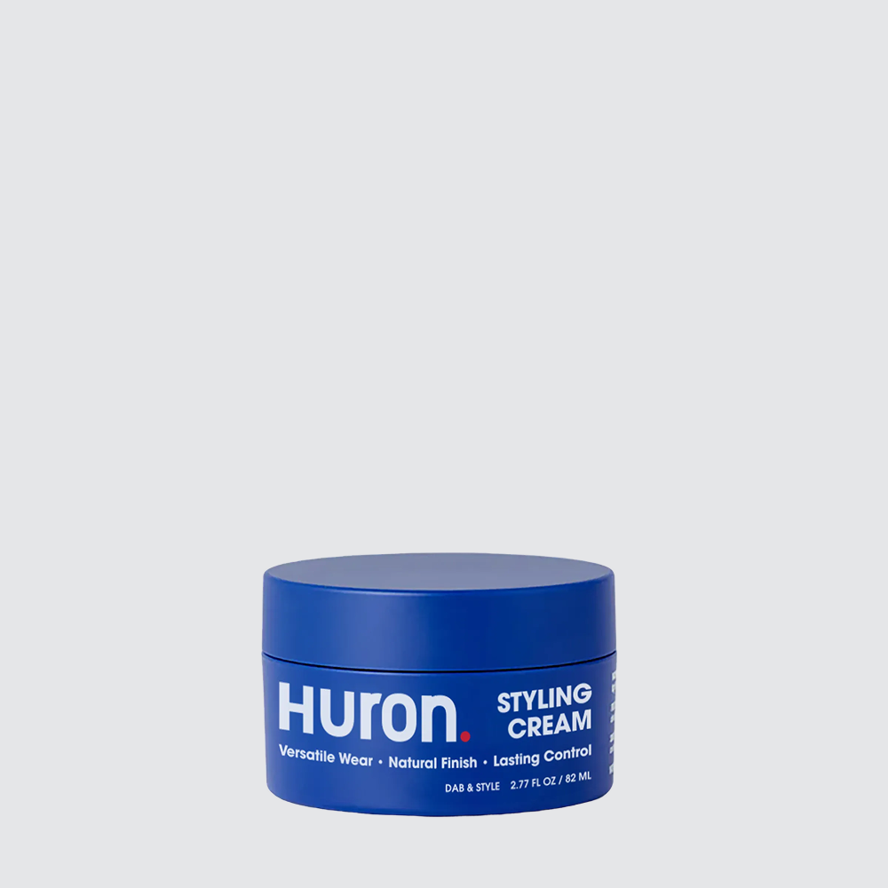 Blue round jar labeled HURON STYLING CREAM on pale background