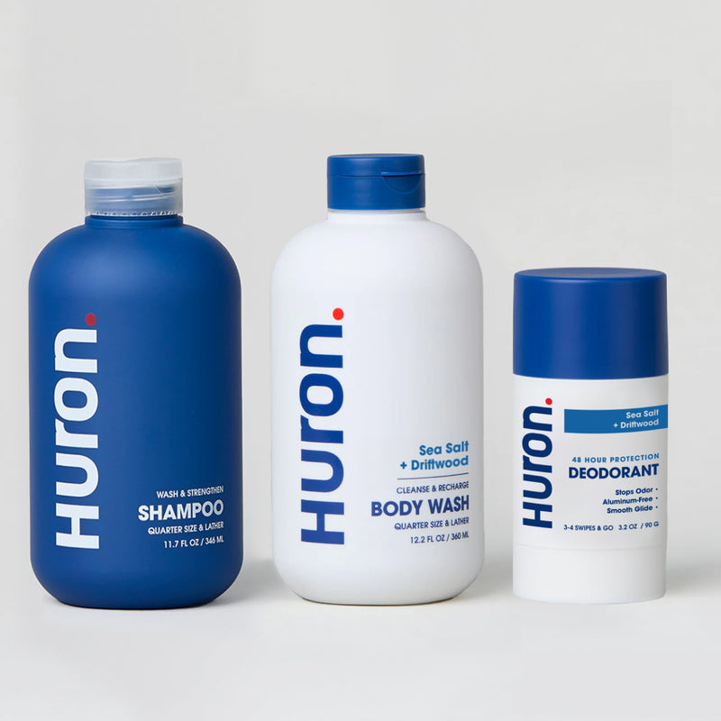 Three Huron personal care products labeled with the scent Sea Salt + Driftwood: shampoo, body wash, and deodorant. #scent_sea salt + driftwood