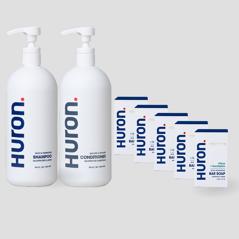 Two white Huron pump bottles labeled Shampoo, Conditioner, and 5 white cartons labeled Huron Bar Soap — Citrus + Eucalyptus scent. #scent_citrus + eucalyptus
