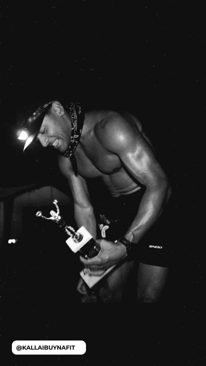 Shirtless man with headlamp and bandana holding a trophy; shorts read ENDO; handle @KALLAIBUYNAFIT visible.