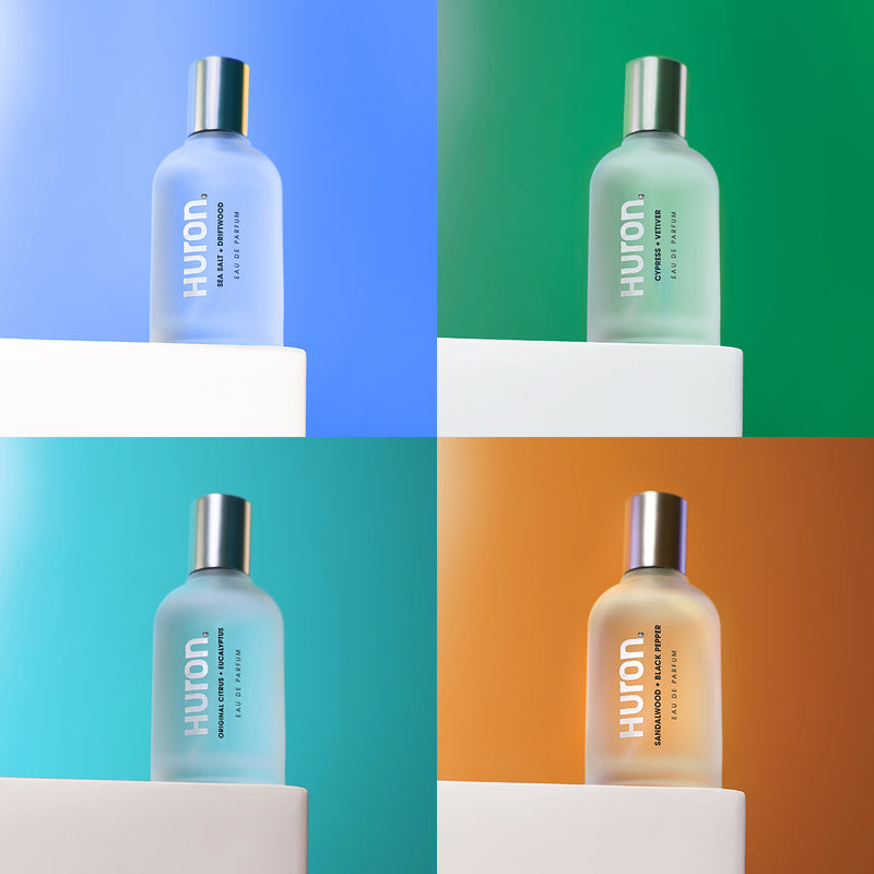 Four bottles of Huron EDP Cologne in various colors on display