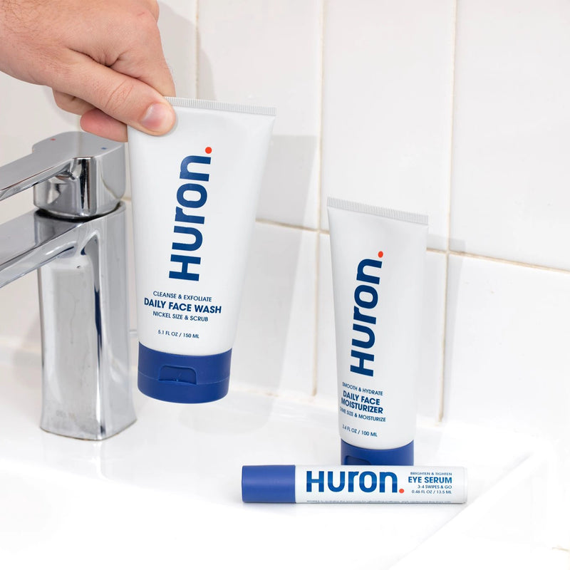 HURTON face wash, moisturizer, and lip balm on a bathroom sink