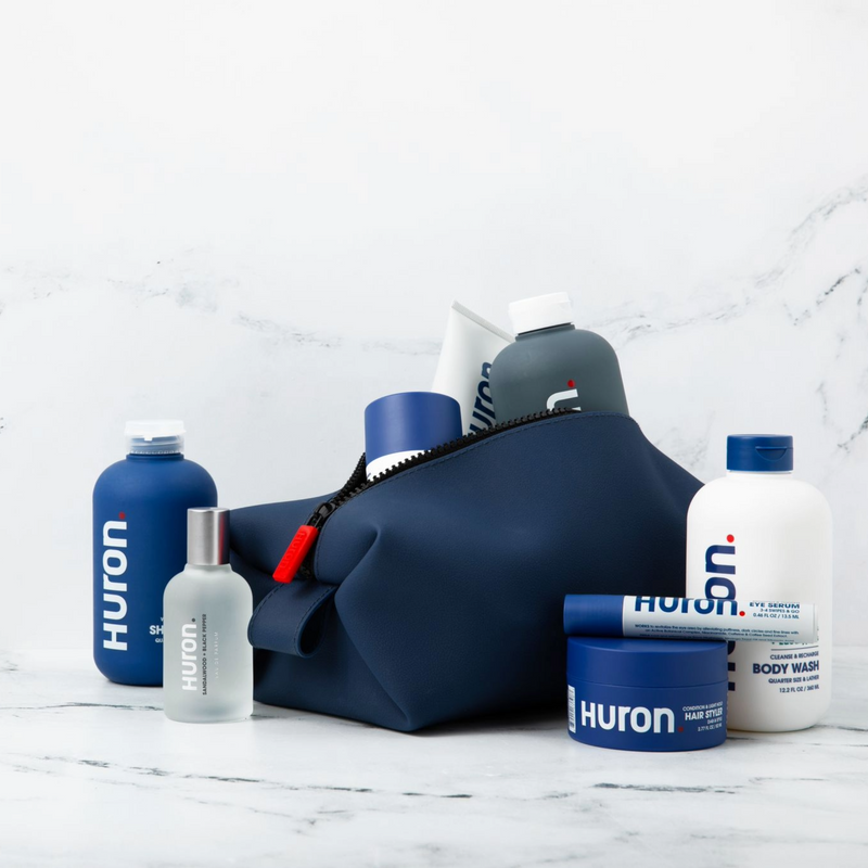 Navy Dopp Kit with Huron skincare products including moisturizer and shampoo