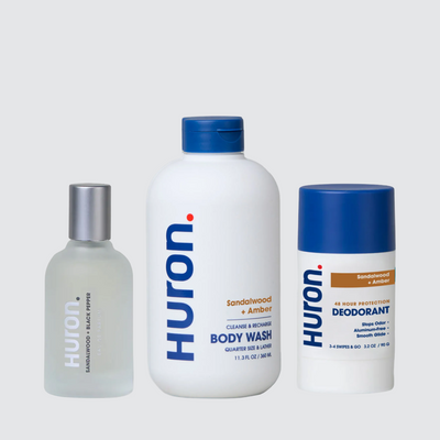 Three Huron. products in Sandalwood + Amber scent: spray, BODY WASH bottle, and DEODORANT stick (48 HOUR PROTECTION) #scent_sandalwood + amber
