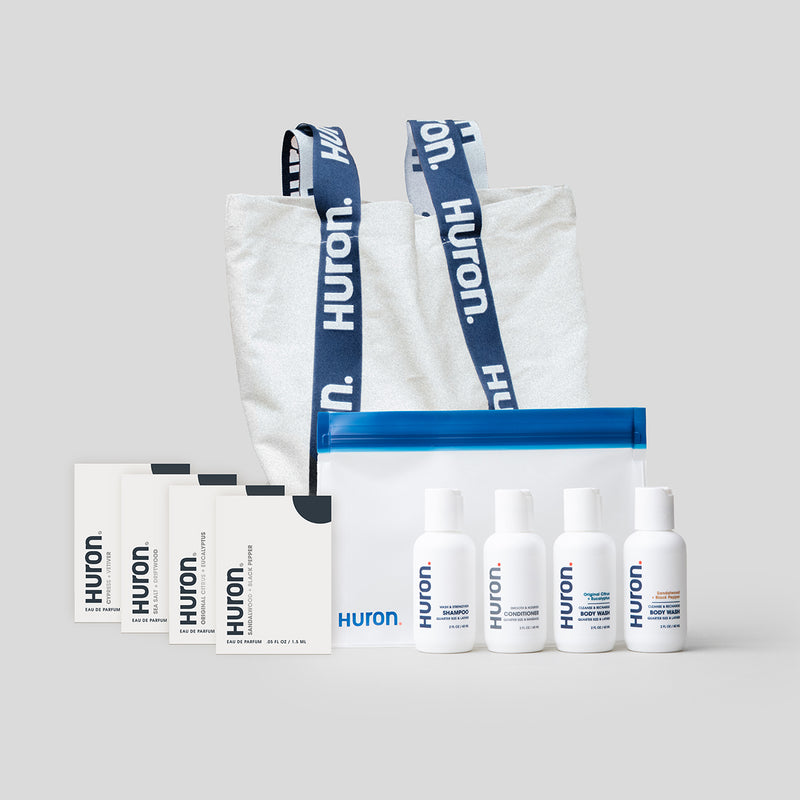 Huron Discovery Set with four product samples, a clear bag, and a tote bag with Huron branding.