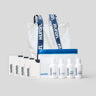 Huron Discovery Set with four product samples, a clear bag, and a tote bag with Huron branding.