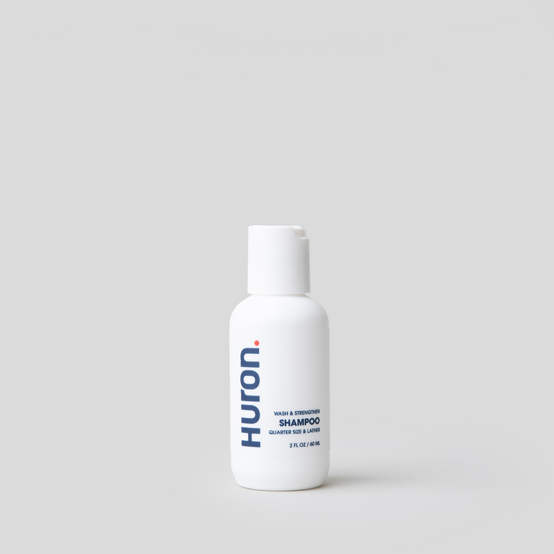 Huron Shampoo Travel Size bottle with white label and blue text